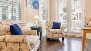 A living room with nautical-themed furniture, a lamp, and a decorative piece on a table. - Emerald Gem by Avantstay Pool Access, 3mins to Beach! (Santa Rosa Beach)