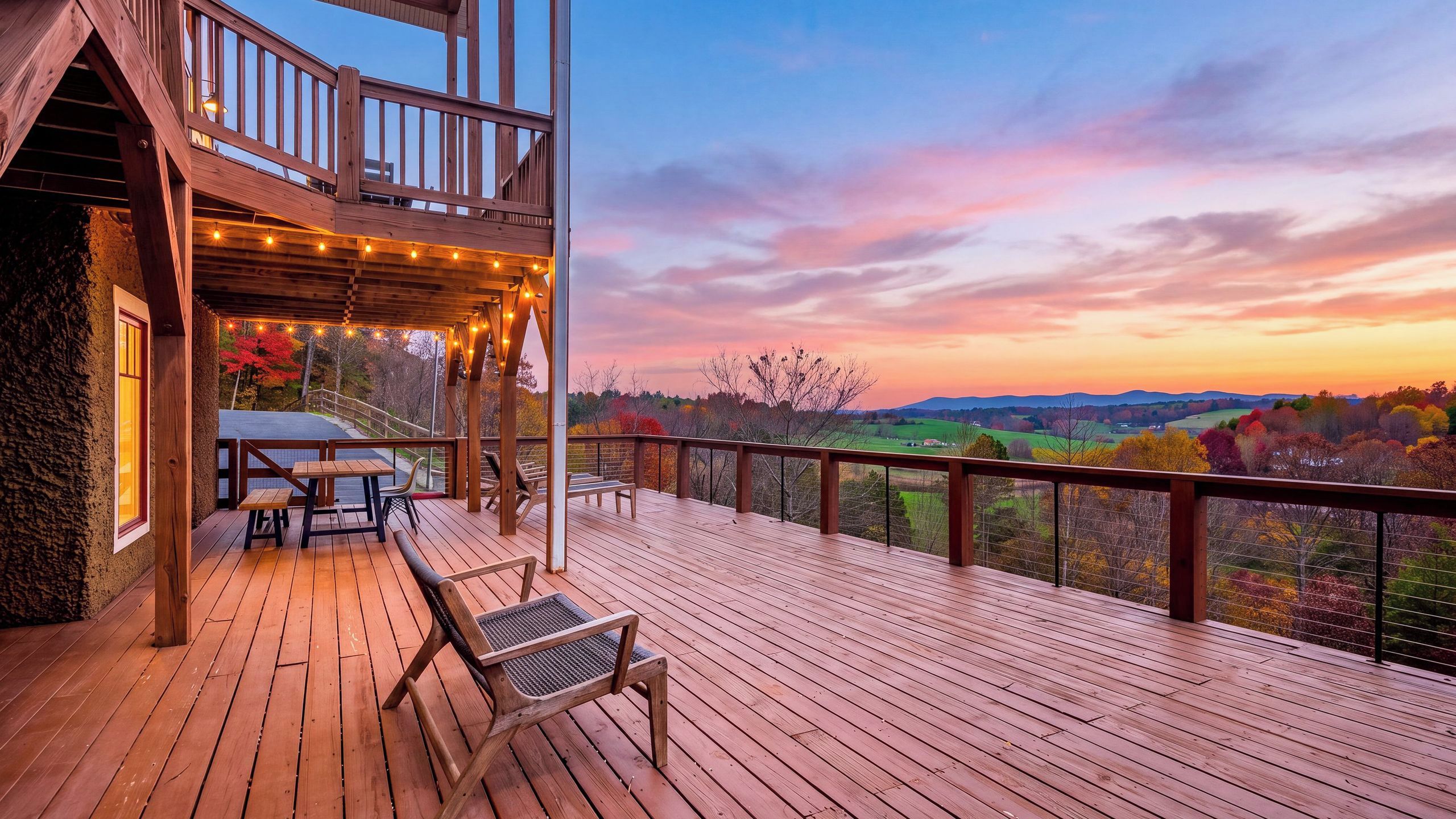 Eine Holzterrasse mit Gartenmöbeln, einem Tisch und Stühlen.