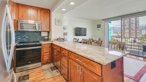 Una cocina moderna con armarios de madera, un horno de acero inoxidable y una isla grande con encimera de mármol.