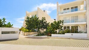 Un edificio moderno con un patio central, que combina balcones y grandes ventanales.