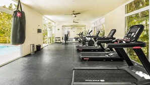 Un gimnasio con cintas de correr, pesas y un saco de boxeo.
