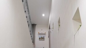A marble staircase leading to a landing with a framed picture and a small decorative item on the wall. - The Two Pine Cones Palermo (Palermo)
