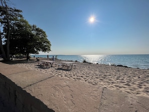 A beach with picnic tables and a clear sky. - Home in Downtown Empire! Walk to the beach! (Empire)
