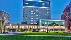 A modern hotel with a glass facade, surrounded by other high-rise buildings. - Tower280 LUXE One-Bedroom Corner Unit with Views! (Rochester)