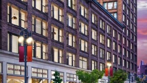 Un immeuble à plusieurs étages, doté d’une façade en briques et de nombreuses fenêtres.