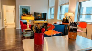 Une cuisine moderne avec une table à manger, des chaises et un téléviseur.