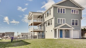 A multi-story residential building with a balcony on the second floor, a garage, and a small porch. - Narragansett Home w/ Scenic Views: Walk to Beach! (Narragansett)