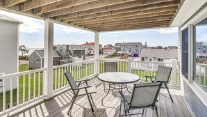 A covered outdoor deck with a table and chairs, overlooking a residential area. - Narragansett Home w/ Scenic Views: Walk to Beach! (Narragansett)