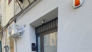 A building entrance with a glass door, a mailbox, and an air conditioning unit on the wall. - Private House 14 Palermo (Palermo)