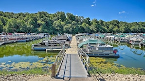 A marina with boats docked, a dock leading to the water, and a forested hillside in the background. - Galena Townhome w/ Deck & Golf Course View! (Galena)