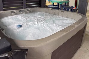 Ein Whirlpool mit fließendem Wasser, umgeben von einer Betonkonstruktion.