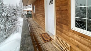 A wooden cabin with a porch, a white door, and a window. - Beautiful Mountainside Escape (Anchorage)