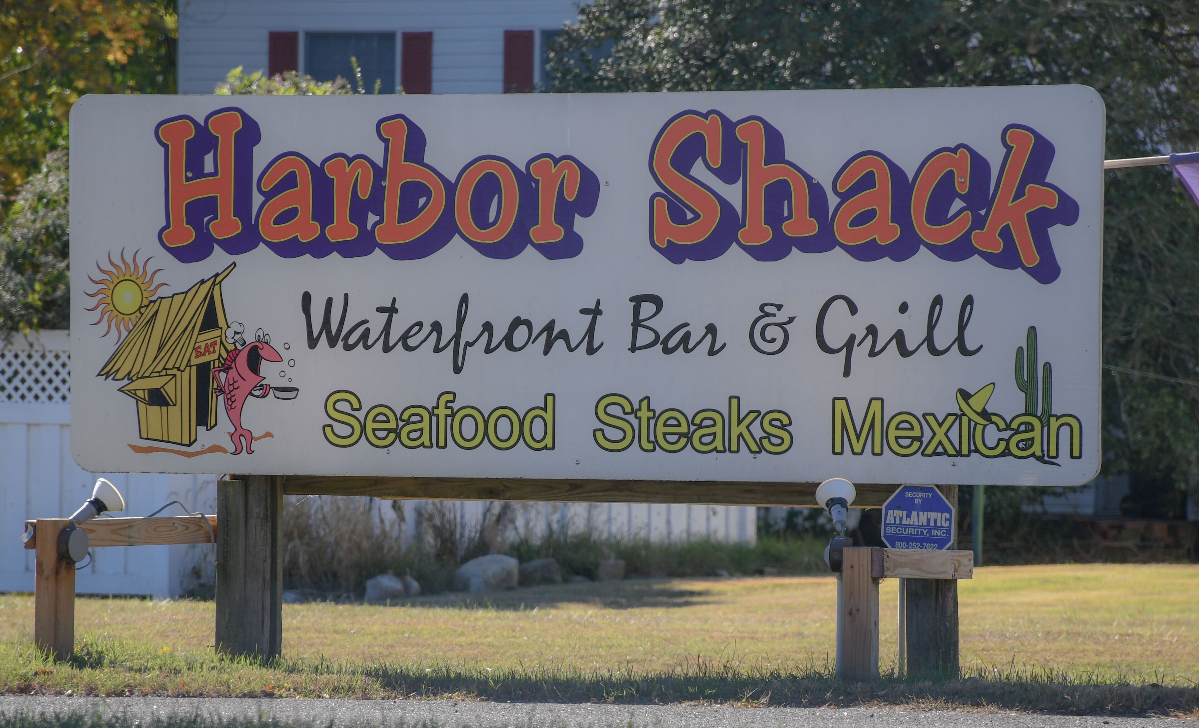 Señal de Harbor Shack, un bar y parrilla frente al mar que ofrece mariscos, filetes y cocina mexicana.