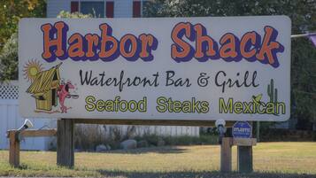 Señal de Harbor Shack, un bar y parrilla frente al mar que ofrece mariscos, filetes y cocina mexicana.