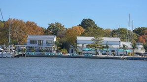 Ein Yachthafen mit vertäuten Booten, ein Gebäude mit weißer Fassade und ein Restaurant mit Außenbereich.
