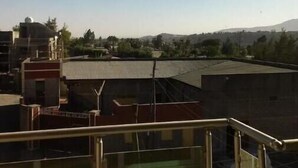 A view from a balcony with a clear sky, buildings in the background, and a distant mountain. - Get More Bang For Your Buck! (Wichita)