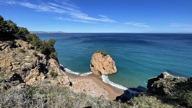 A coastal landscape with a prominent rocky outcrop, clear blue sea, and a sandy beach. - The Getaway, your temporary home away from home (Pals)