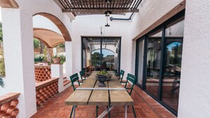 An outdoor patio with a wooden table and chairs, a pergola, and a view of the surrounding landscape. - The Getaway, your temporary home away from home (Pals)