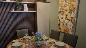 Een eethoek met een ronde tafel gedekt voor zes personen, omringd door stoelen.