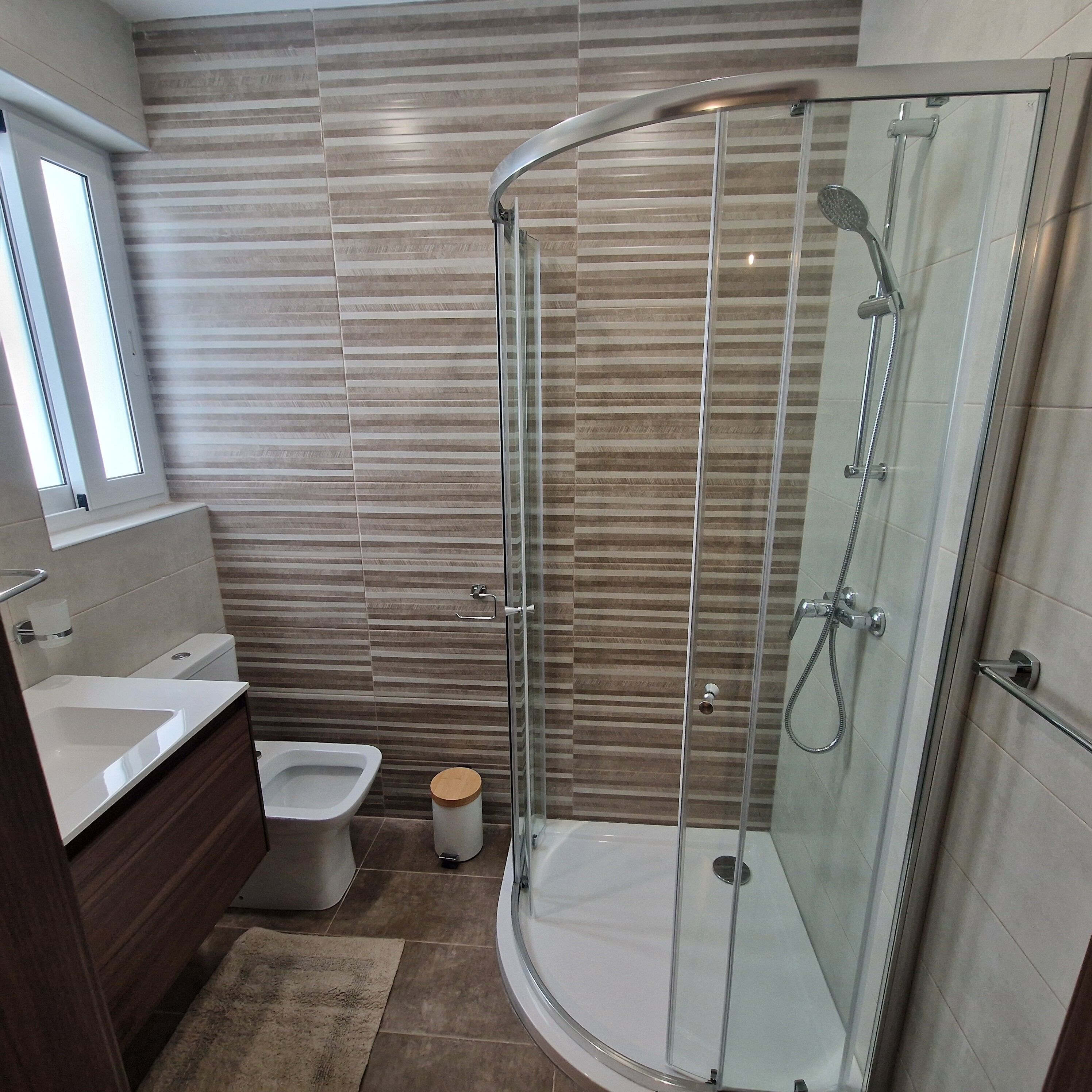 Une salle de bain moderne avec une douche à parois de verre, des toilettes et un bidet.
