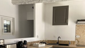 A modern kitchen with grey cabinets, a wooden countertop, and a built-in dishwasher. - Gîtes Chez Prune Entièrement Rénové Avec Piscine Privée (Rasteau)