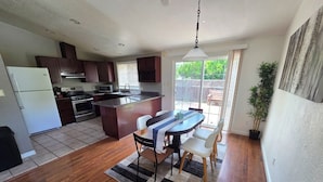A modern kitchen with a central island, dining area with chairs, and a large window with a view. - Beautiful, spacious 3 bedroom Napa Adjacent hideaway. Pet and family friendly  (American Canyon)
