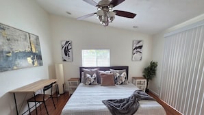 A bedroom with a bed, a desk, a ceiling fan, and artwork on the walls. - Beautiful, spacious 3 bedroom Napa Adjacent hideaway. Pet and family friendly  (American Canyon)