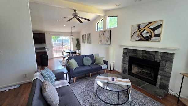 A living room with a sofa, a fireplace, a ceiling fan, and artwork on the walls. - Beautiful, spacious 3 bedroom Napa Adjacent hideaway. Pet and family friendly  (American Canyon)