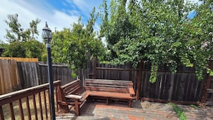A wooden deck with a bench, a metal fence, and a tree. - Beautiful, spacious 3 bedroom Napa Adjacent hideaway. Pet and family friendly  (American Canyon)