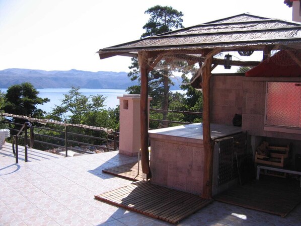 A covered outdoor area with a view of a lake and mountains. - Lantana ex.Vila Americana (Karlobag)