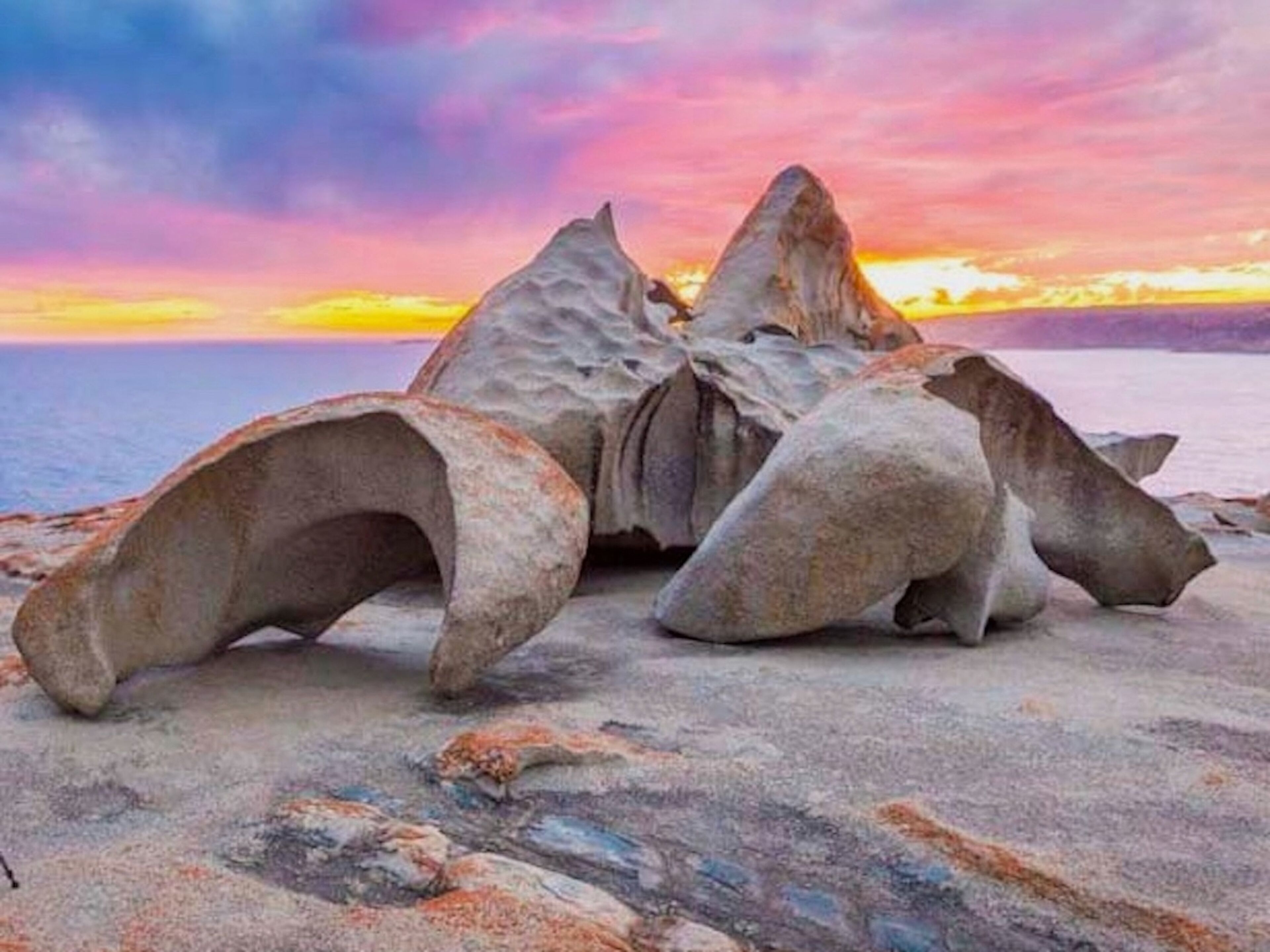 A rock formation with a sunset in the background.