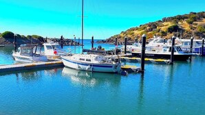 A marina with several boats docked, calm water, and a clear sky. - Cove Landing Ocean View Apt-02 James Comrie Sleeps 4 (Penneshaw)