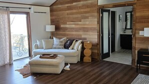 Un salon moderne avec un plafond en pente en bois, un canapé, une table basse et un tapis.