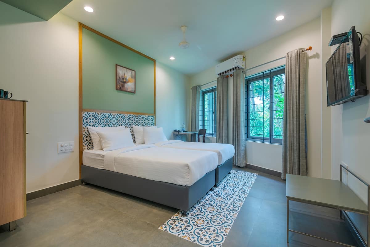 A modern bedroom with a large bed, a desk, and a window with curtains.