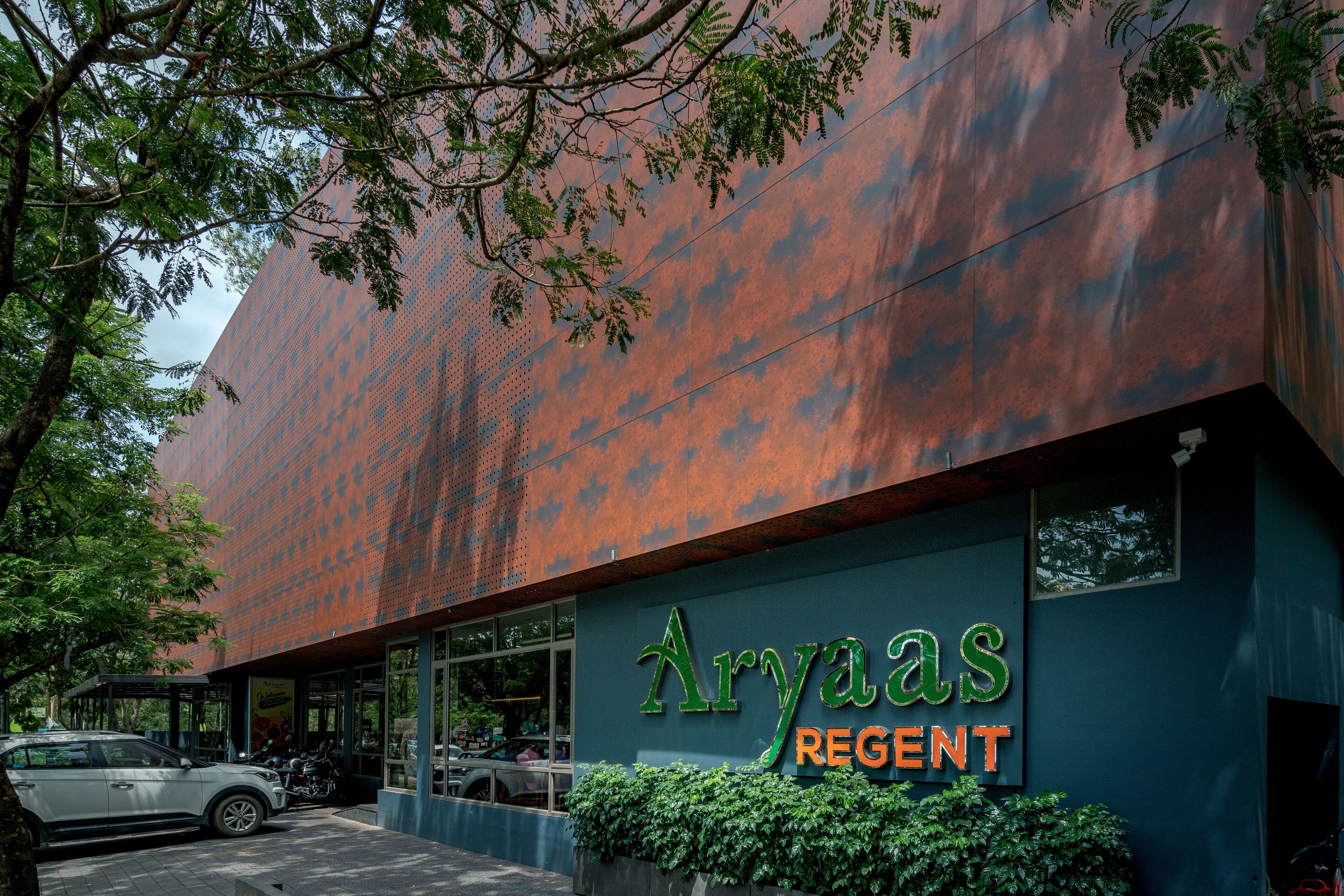 A building with a metal exterior and a sign reading "Aryas Regent".