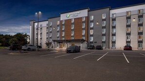 A multi-story hotel with a modern design, featuring a prominent sign for 'Woodspring Suites'. - WoodSpring Suites Winston-Salem near Hanes Mall (Winston-Salem)
