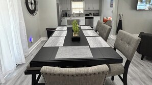 Une cuisine moderne avec des armoires blanches, une horloge noire et une enseigne sur laquelle on peut lire « CUISINE ».