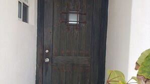 A dark wooden door with a small window and a metal latch.