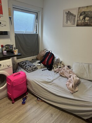 Cozy retreat with a single bed, washing machine, and ample storage for your travels.