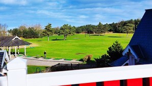 A golf course with a pavilion, surrounded by trees and residential buildings. - Appartement Belle Dune 2 Chambres (Fort-Mahon Plage)