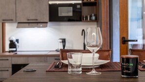 Une table à manger avec un verre à vin, un petit verre et une bougie dans un chandelier.