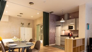 Une cuisine moderne avec un coin repas, des meubles en bois et un petit îlot central.