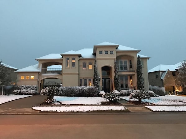 A large, multi-story house with a symmetrical facade, a central entrance, and snow-covered landscaping. - Welcome to 5BR Luxury Home With Pool in beautiful Katy, Texas (Katy)