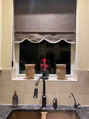 A bathroom with a sink, two bottles of soap, a mirror, and a window with a decorative valance. - Welcome to 5BR Luxury Home With Pool in beautiful Katy, Texas (Katy)