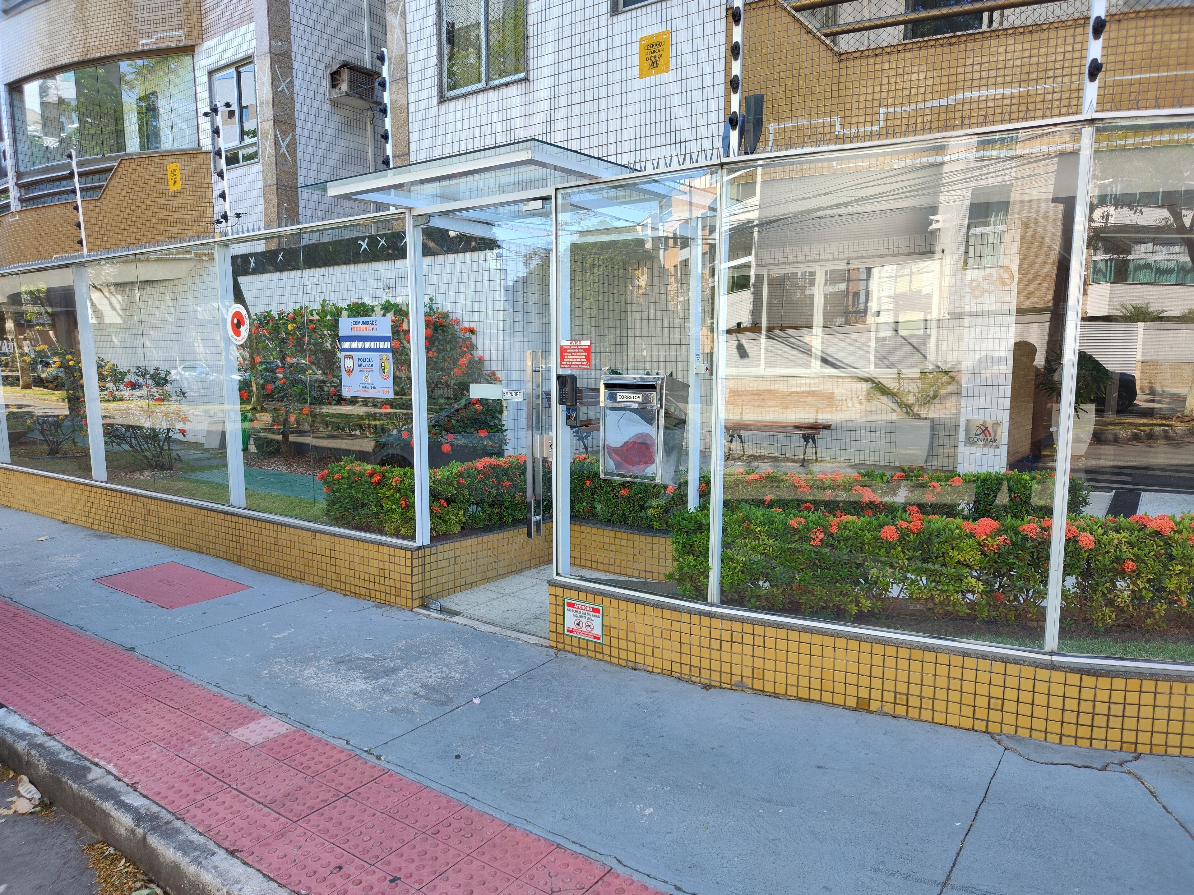 A bus stop with a shelter, a bench, and a flower bed.