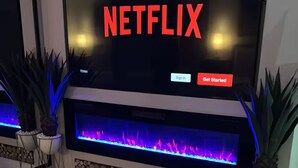 Una sala de estar moderna con un televisor de pantalla plana grande sobre una chimenea.