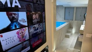 Una sala de estar moderna con un televisor de pantalla plana grande que muestra varios servicios de transmisión.