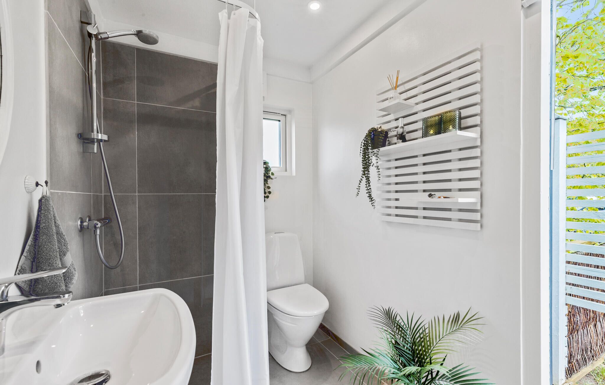 Un baño moderno con ducha, inodoro y lavamanos.