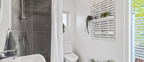 Un baño moderno con ducha, inodoro y lavamanos.