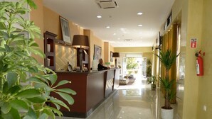 A hotel reception area with a reception desk, a receptionist, and a reception sign. - Maraval Hotel Oran (Oran)